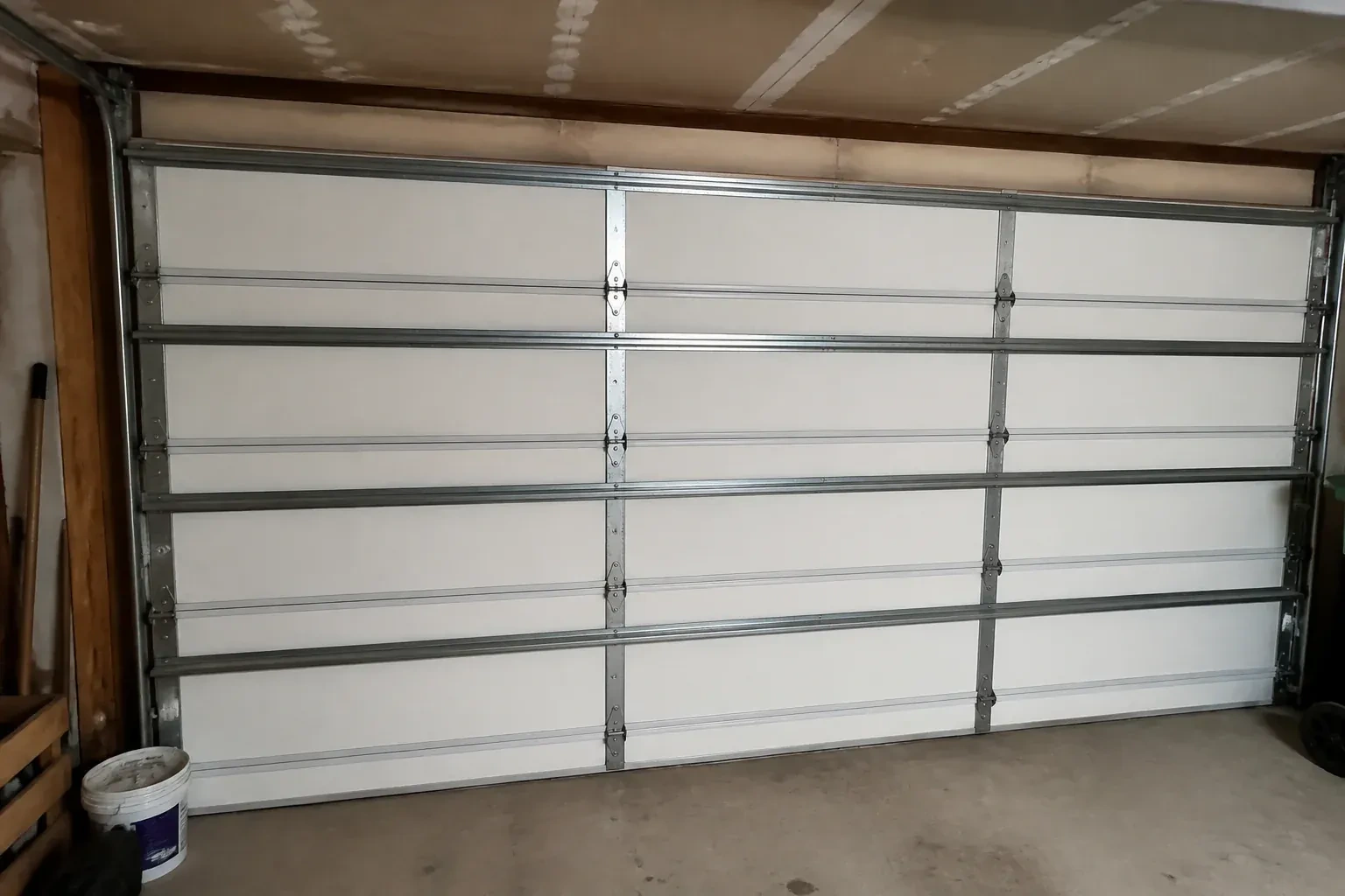 Interior of a closed sectional door with horizontal metal reinforcement struts. — Wind-Rated Garage Door Replacement, Port Colborne